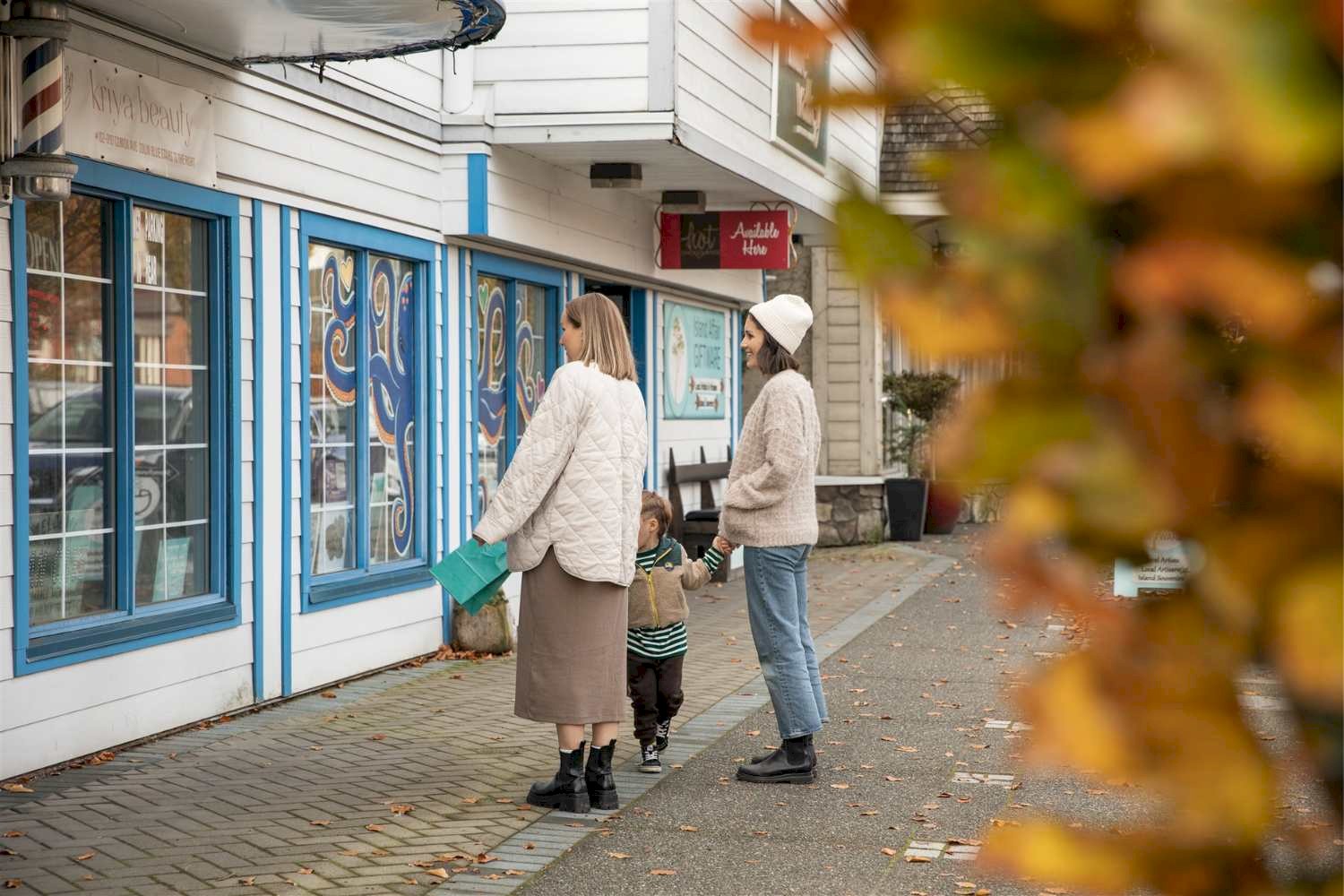 Three people window shopping on Comox Ave
