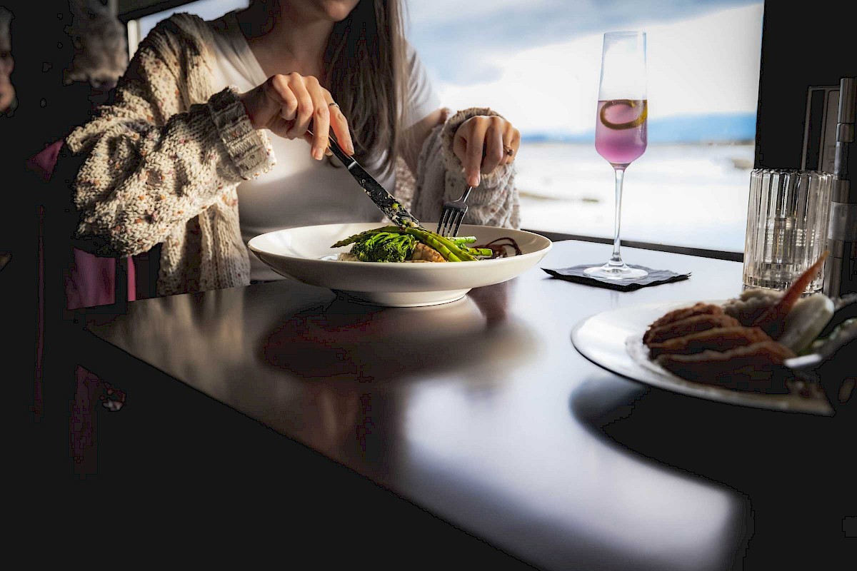 Woman at a restaurant cutting into a plate of food