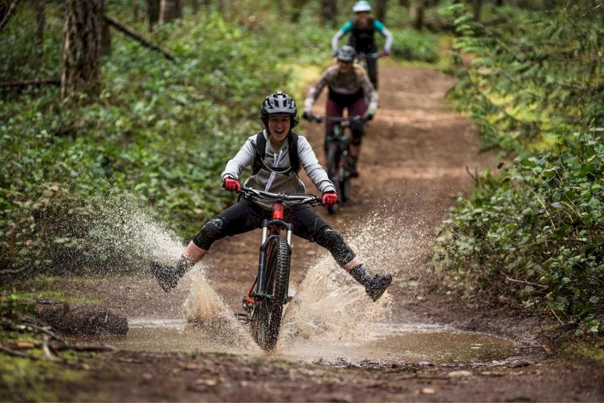 Person mountain biking through a puddle